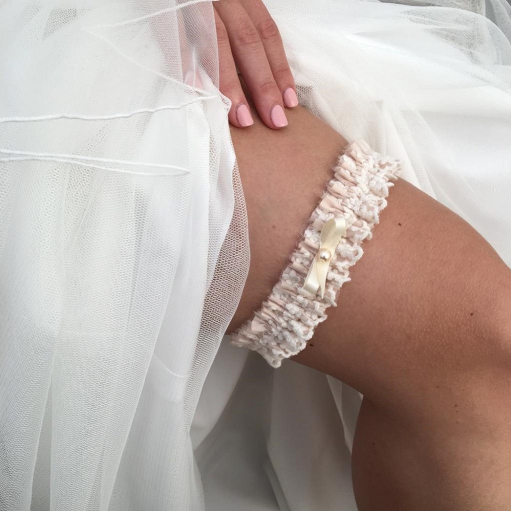 Photograph of Harmony Blush Silk and Ivory Lace Wedding Garter with Pearl Bow